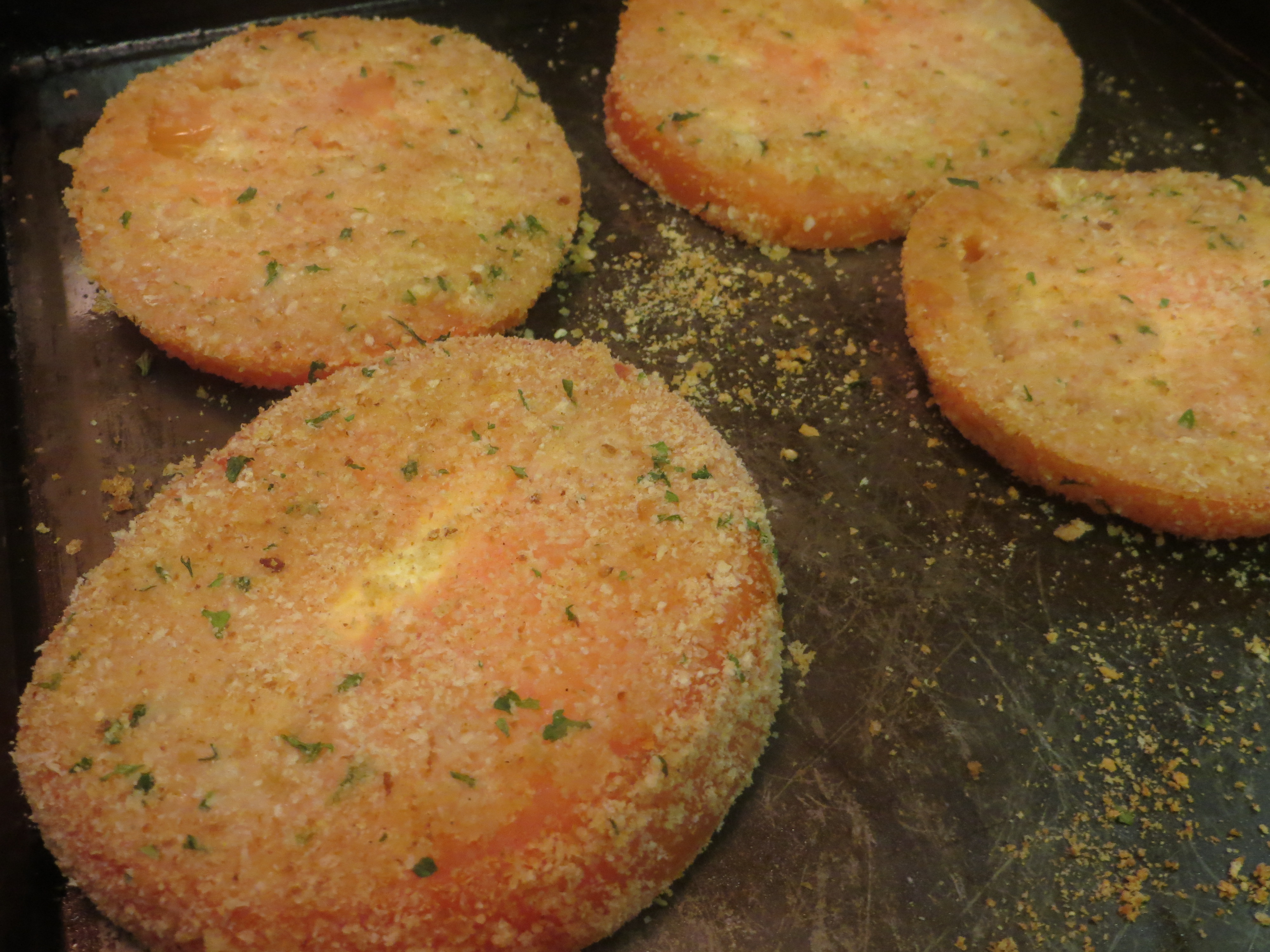 Sliced tomatoes coated with bread crumbs, parmesan cheese, salt and pepper.