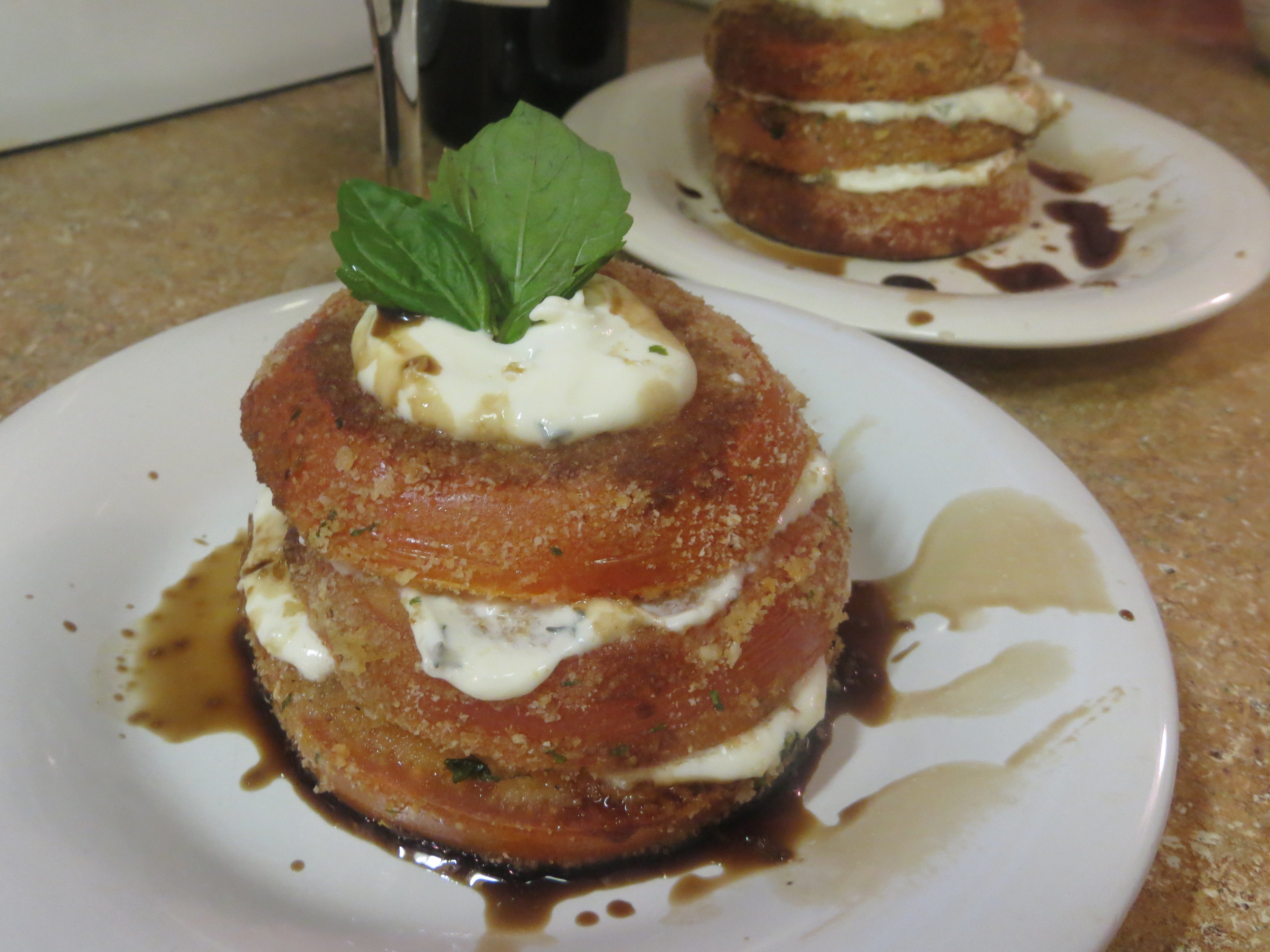Three-layered Breaded Tomatoes Napoleon with balsamic drizzled around the edges for dipping.