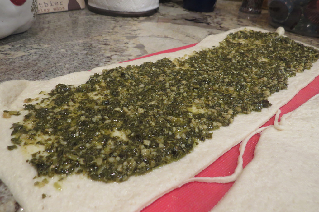 Step 3: Top one of the halves with pesto, leaving at least 1/2"border on all four sides.