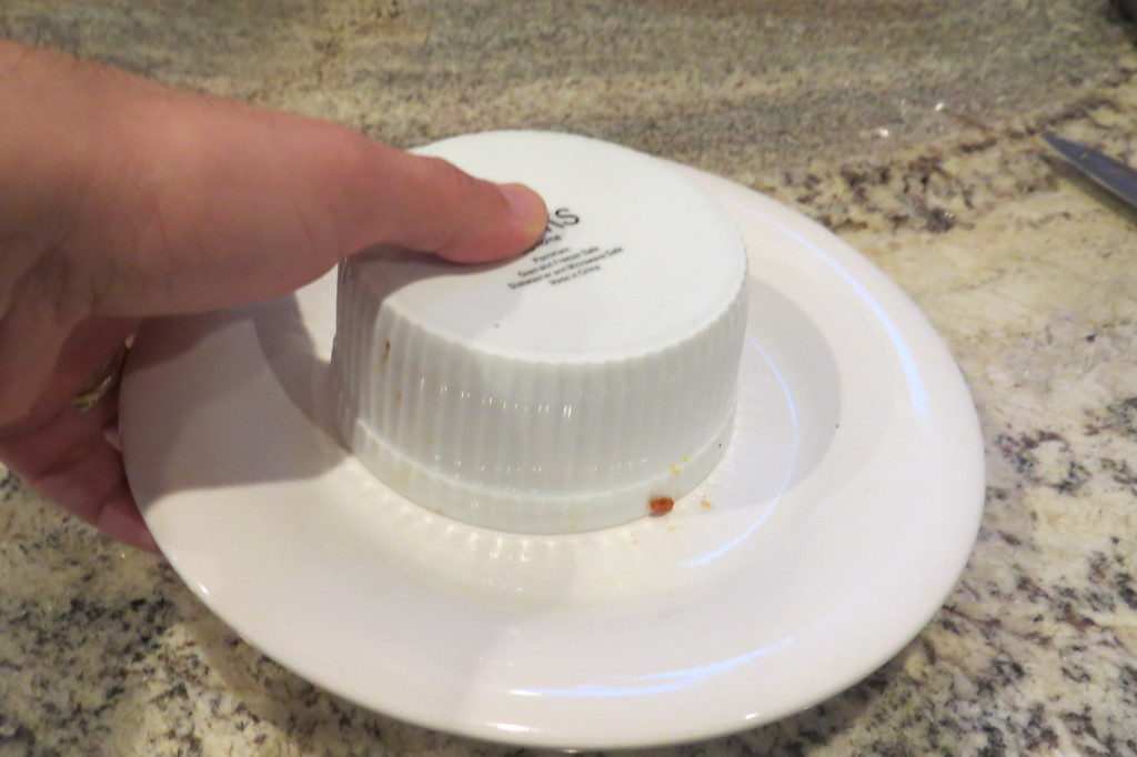 Carefully flipping the timbale onto the dish.