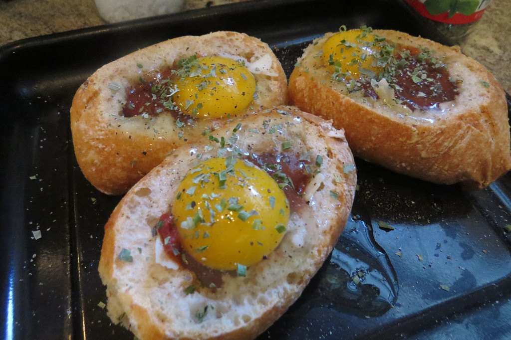Gently crack an egg over the top of the roll. Top with salt, pepper and fresh herbs (basil or Italian seasoning work well).