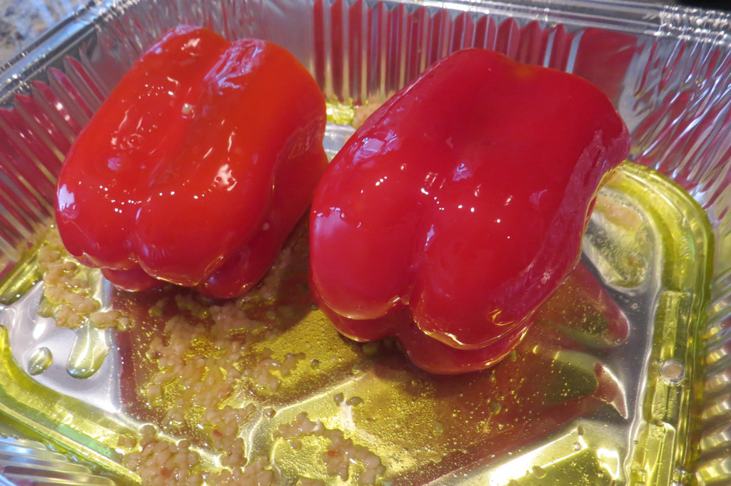 Step 1 - remove the cap, core and seeds from 2 to 3 red bell peppers. Place in an aluminum tray, drizzle with 1/2 cup olive oil. Add a few cloves of garlic, whole or minced, to the tray. Cover with foil.